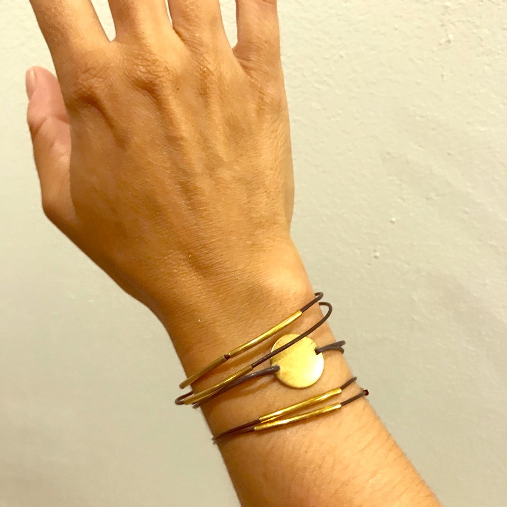 Bundle of three metal and leather bracelets.